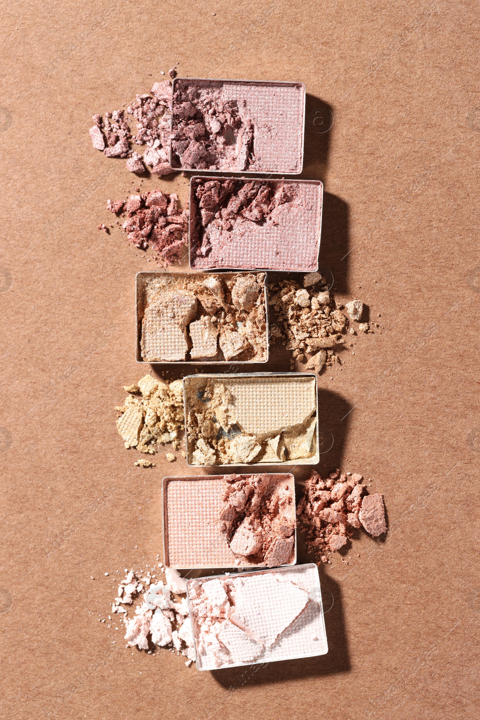 Beautiful eyeshadow refill pans on brown background, flat lay Photo of Beautiful eyeshadow refill pans on brown background, flat lay