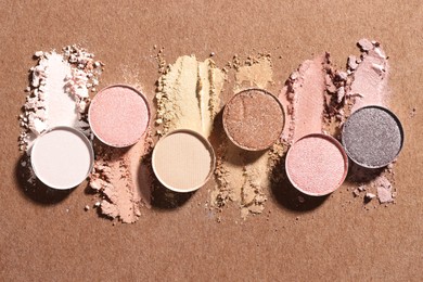 Photo of Beautiful eyeshadow refill pans on brown background, flat lay