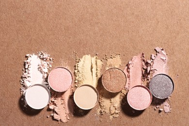 Photo of Beautiful eyeshadow refill pans on brown background, flat lay. Space for text
