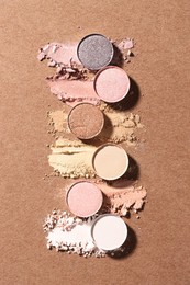 Photo of Beautiful eyeshadow refill pans on brown background, flat lay