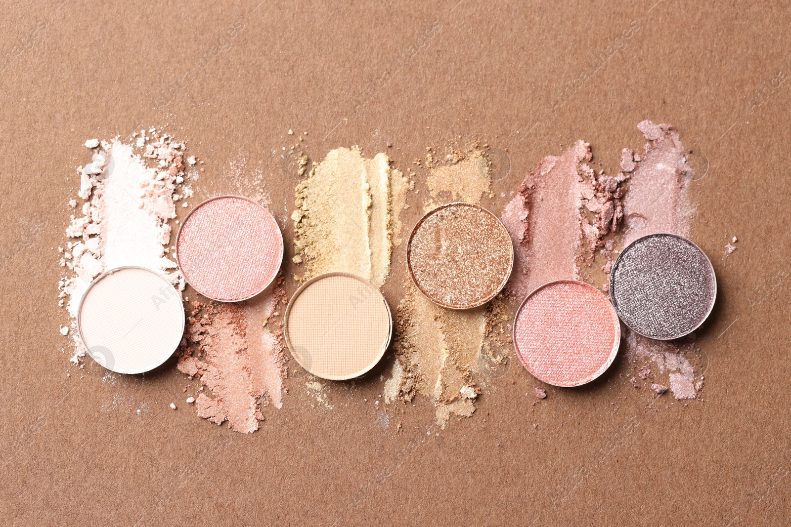 Beautiful eyeshadow refill pans on brown background, flat lay Photo of Beautiful eyeshadow refill pans on brown background, flat lay