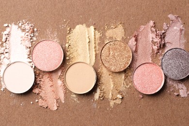 Photo of Beautiful eyeshadow refill pans on brown background, flat lay
