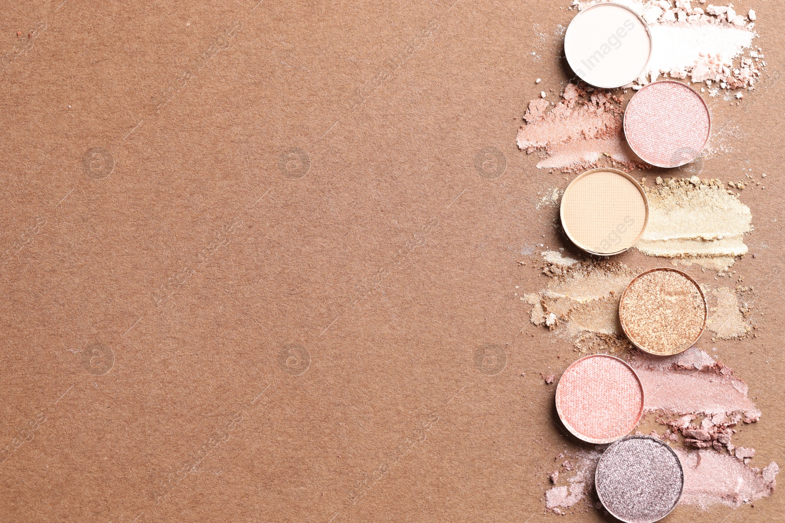 Beautiful eyeshadow refill pans on brown background, flat lay. Space for text Photo of Beautiful eyeshadow refill pans on brown background, flat lay. Space for text