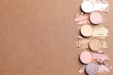 Photo of Beautiful eyeshadow refill pans on brown background, flat lay. Space for text