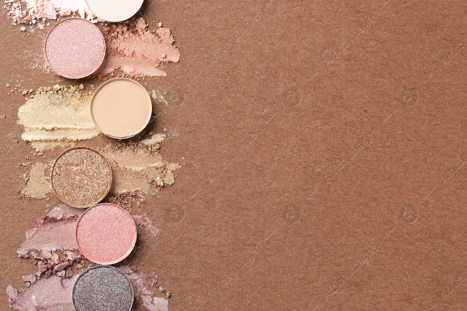 Beautiful eyeshadow refill pans on brown background, flat lay. Space for text Photo of Beautiful eyeshadow refill pans on brown background, flat lay. Space for text