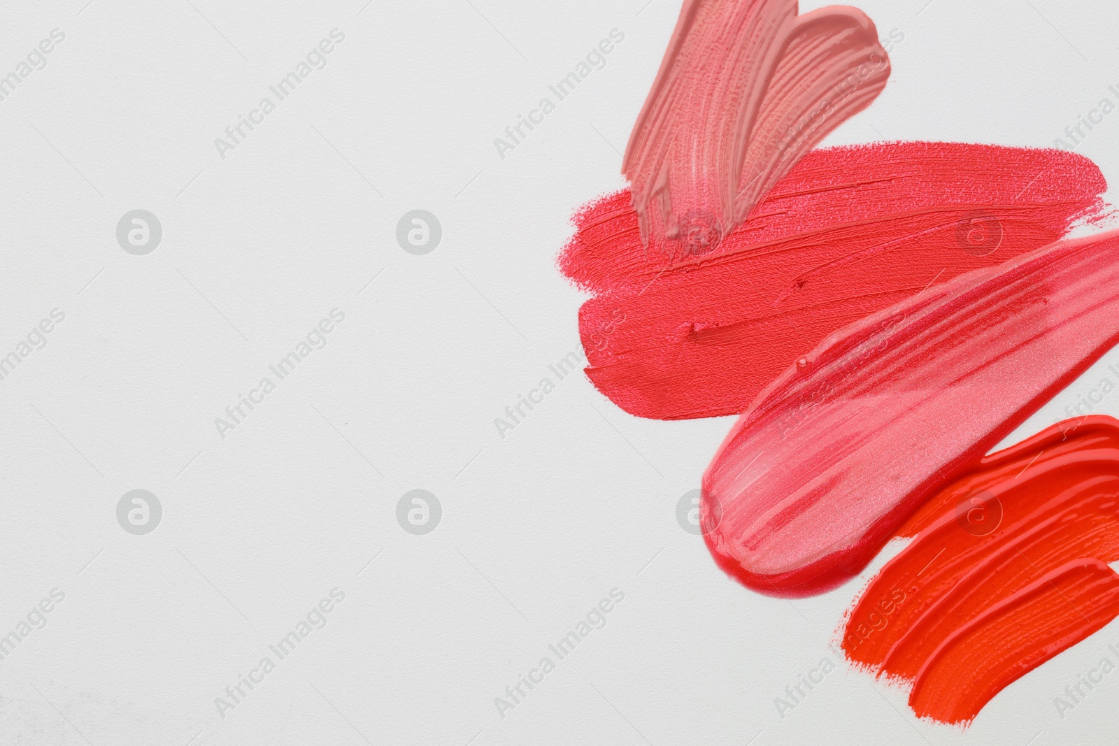 Photo of Samples of different lipsticks on white background, flat lay. Space for text