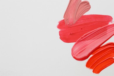 Photo of Samples of different lipsticks on white background, flat lay. Space for text