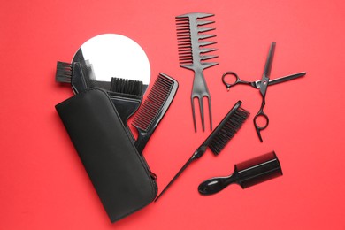 Photo of Different hairdresser's tools on red background, flat lay