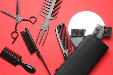 Photo of Different hairdresser's tools on red background, flat lay