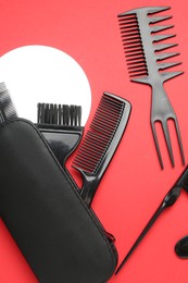 Photo of Different hairdresser's tools on red background, flat lay