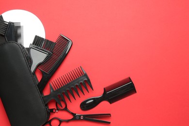 Photo of Different hairdresser's tools on red background, flat lay. Space for text