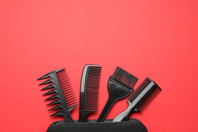 Photo of Different hairdresser's tools and case on red background, flat lay. Space for text