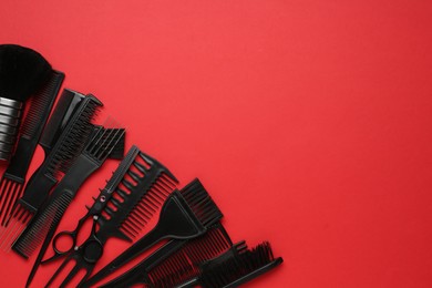 Photo of Different hairdresser's tools on red background, flat lay. Space for text