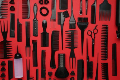 Photo of Different hairdresser's tools on red background, flat lay