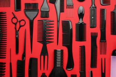 Photo of Different hairdresser's tools on red background, flat lay