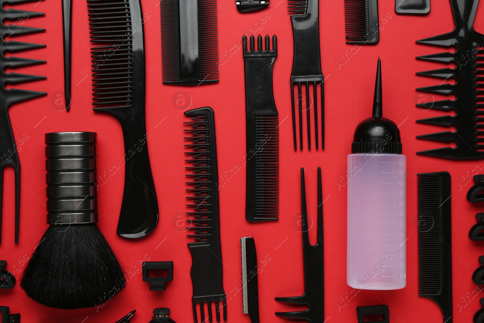 Photo of Different hairdresser's tools on red background, flat lay