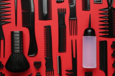 Photo of Different hairdresser's tools on red background, flat lay