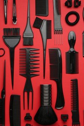 Photo of Different hairdresser's tools on red background, flat lay