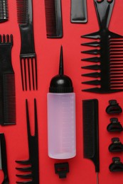Photo of Different hairdresser's tools on red background, flat lay