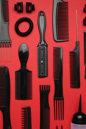 Photo of Different hairdresser's tools on red background, flat lay