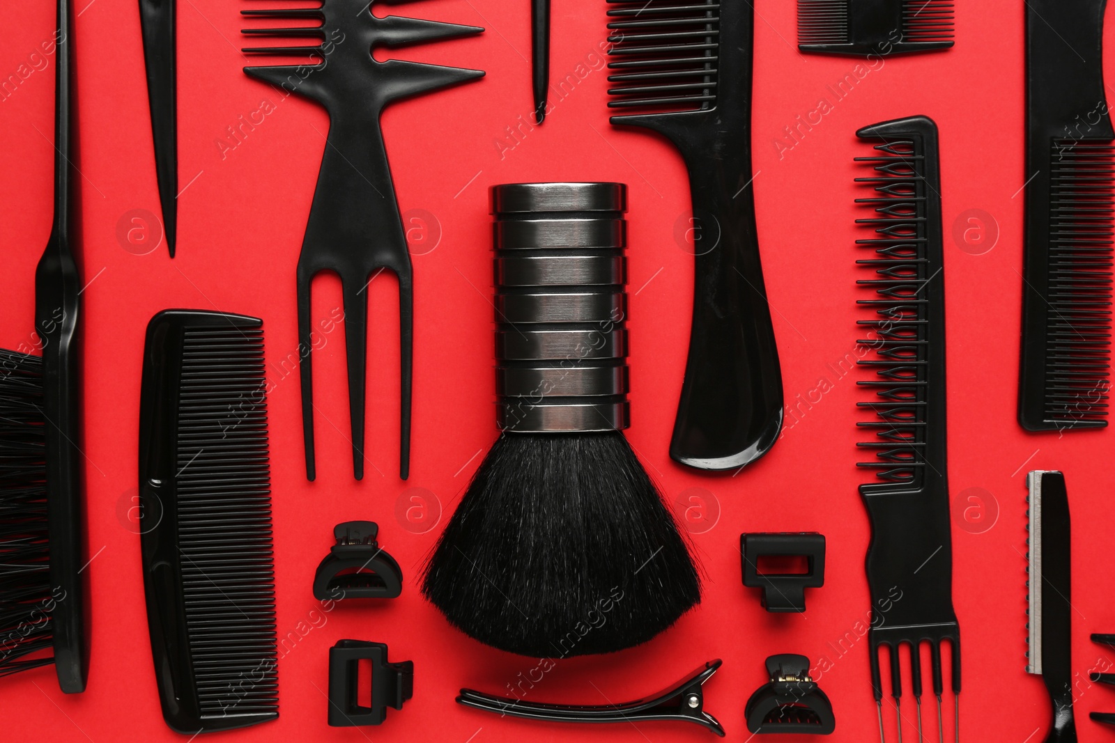 Photo of Different hairdresser's tools on red background, flat lay