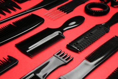 Photo of Different hairdresser's tools on red background, closeup