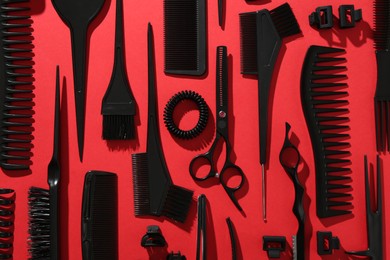 Photo of Different hairdresser's tools on red background, flat lay