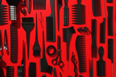 Photo of Different hairdresser's tools on red background, flat lay