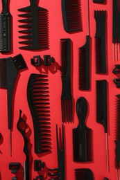 Photo of Different hairdresser's tools on red background, flat lay