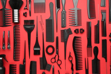 Photo of Different hairdresser's tools on red background, flat lay