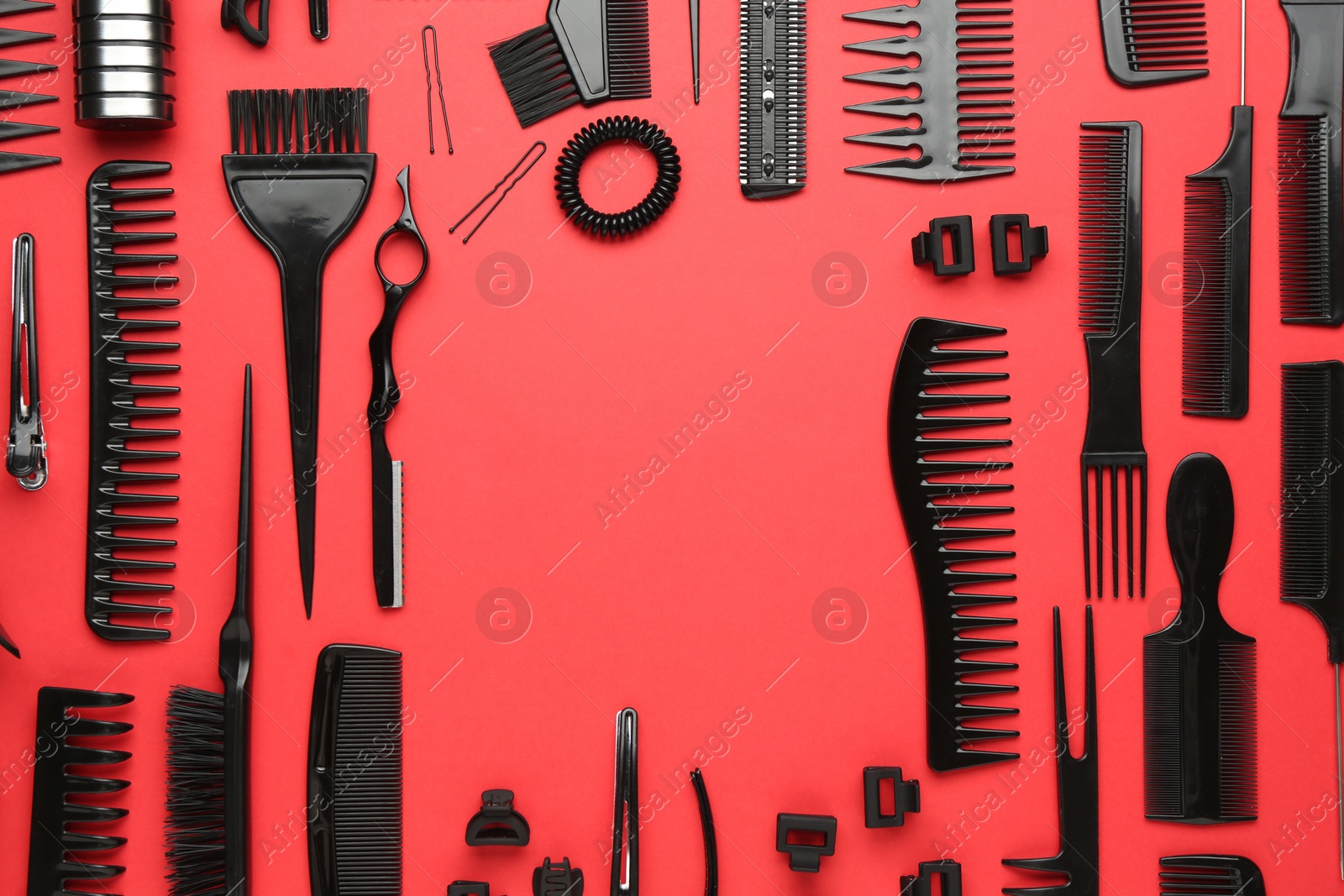 Photo of Frame of different hairdresser's tools on red background, flat lay. Space for text