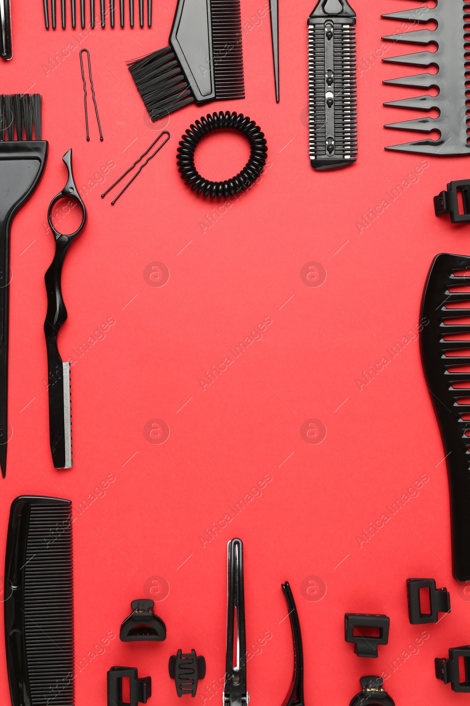 Photo of Frame of different hairdresser's tools on red background, flat lay. Space for text