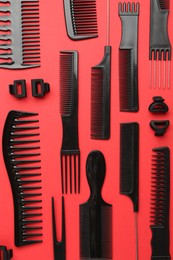 Photo of Different hairdresser's tools on red background, flat lay