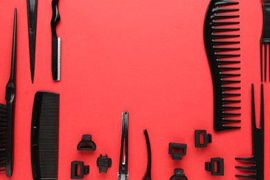 Photo of Different hairdresser's tools on red background, flat lay. Space for text