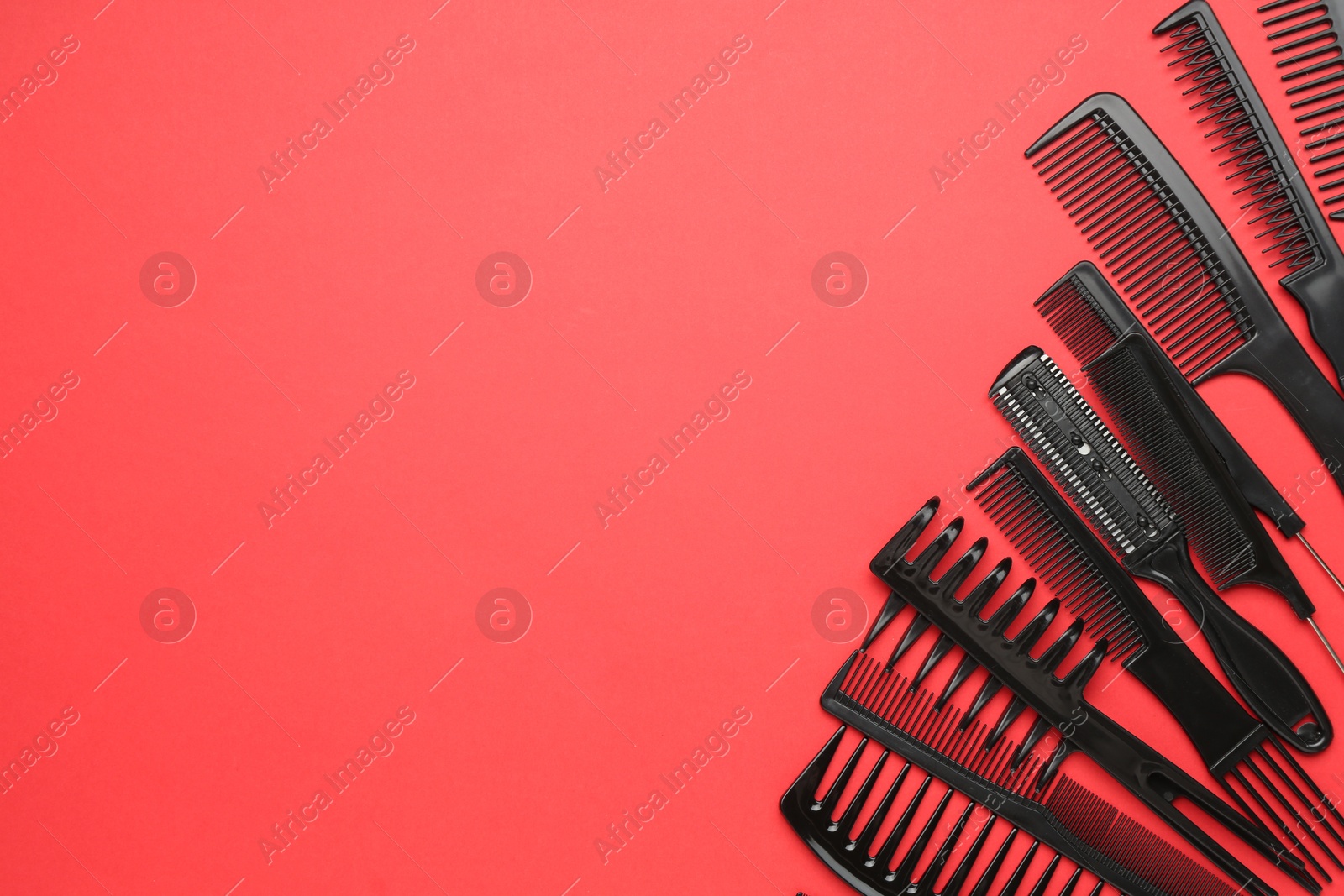 Photo of Different hairdresser's tools on red background, flat lay. Space for text
