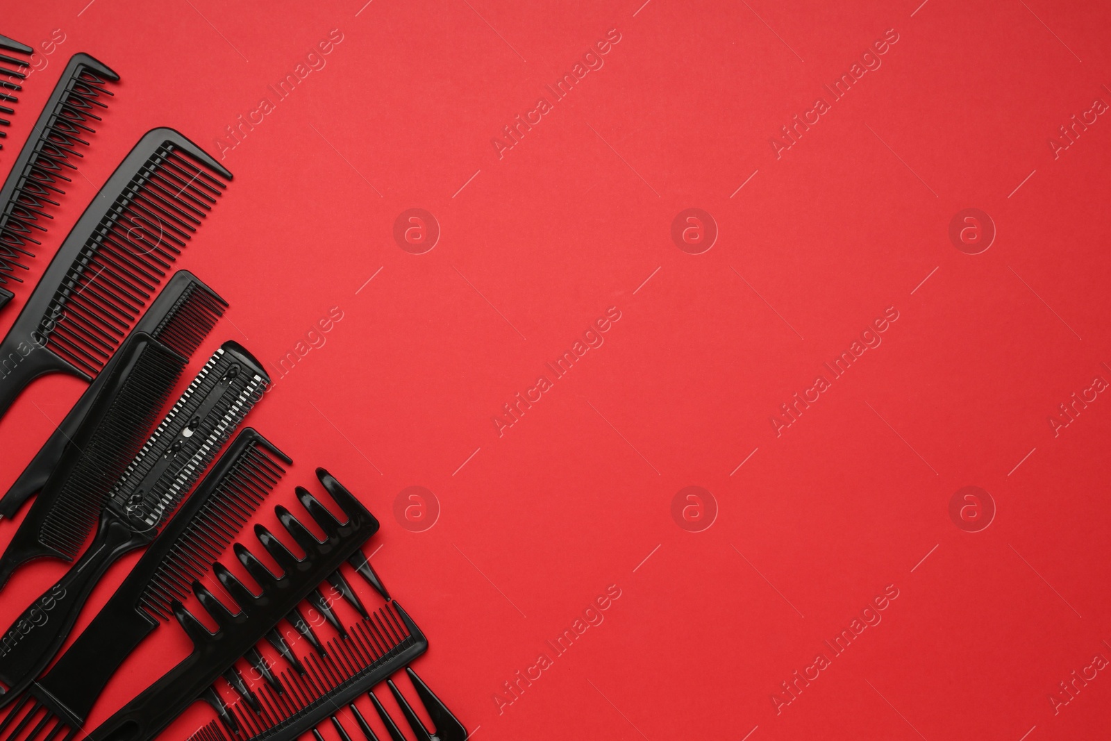 Photo of Different hairdresser's tools on red background, flat lay. Space for text