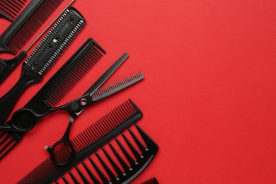 Photo of Different hairdresser's tools on red background, flat lay. Space for text