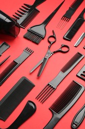 Photo of Different hairdresser's tools on red background, above view