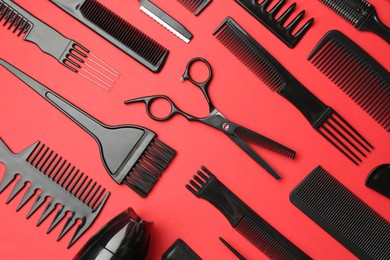 Photo of Different hairdresser's tools on red background, flat lay