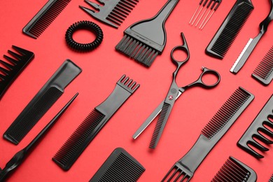 Photo of Different hairdresser's tools on red background, above view