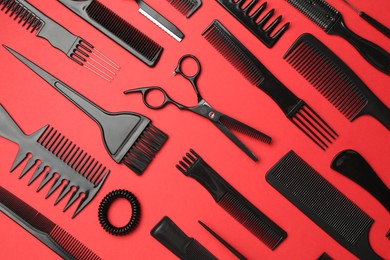 Photo of Different hairdresser's tools on red background, flat lay