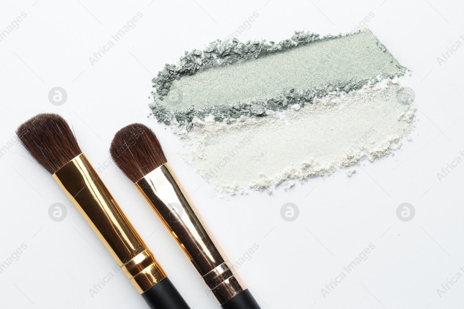Eyeshadow smudges and brushes on white background, flat lay Photo of Eyeshadow smudges and brushes on white background, flat lay