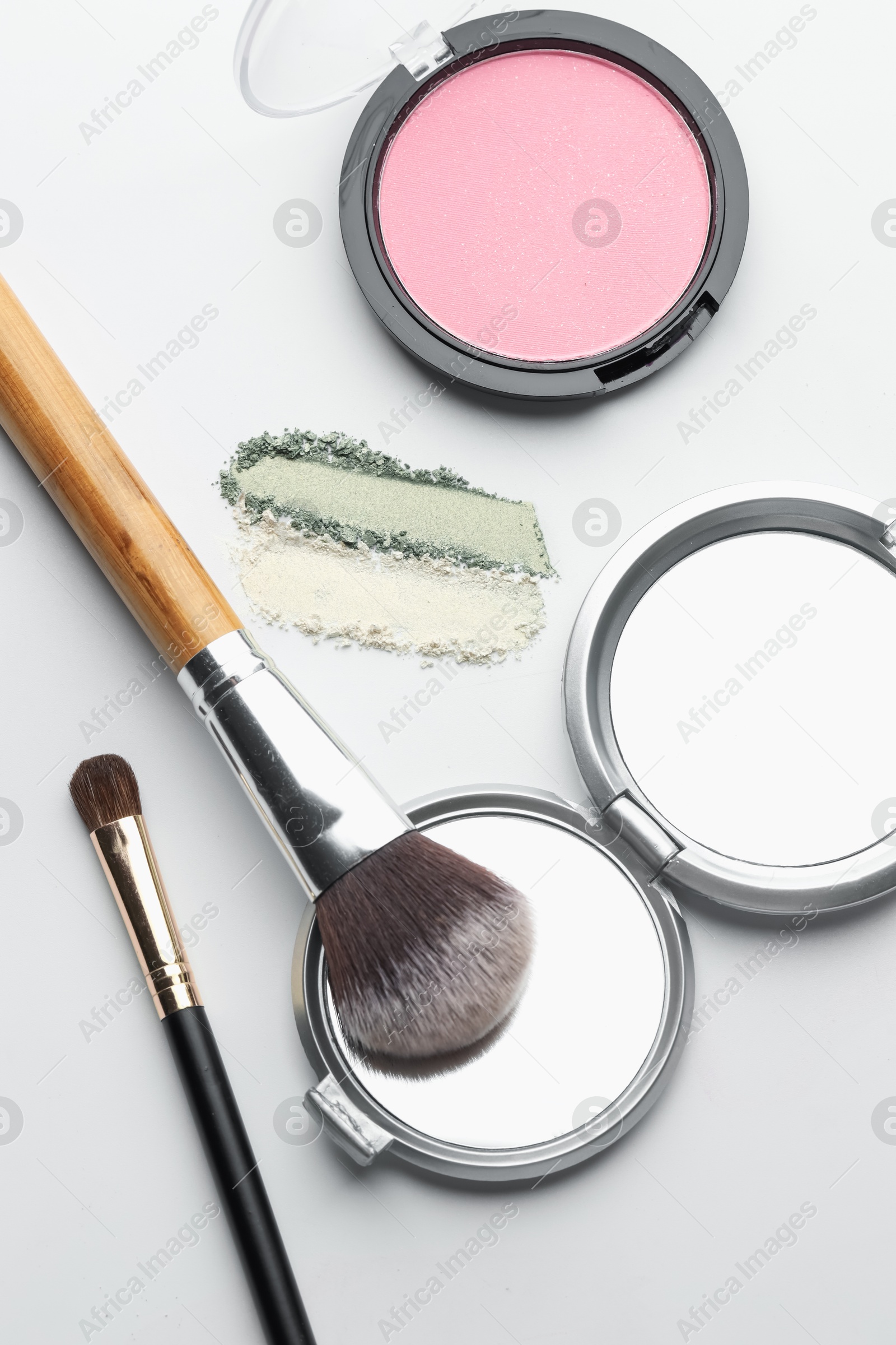 Different makeup products and brushes on white background, flat lay Photo of Different makeup products and brushes on white background, flat lay