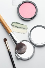 Photo of Different makeup products and brushes on white background, flat lay