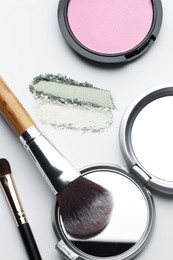 Photo of Different makeup products and brushes on white background, flat lay