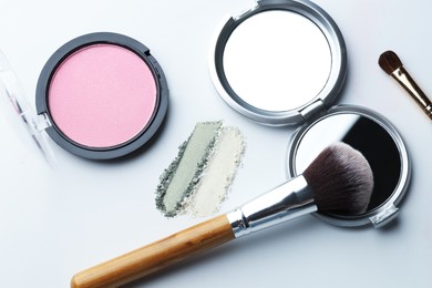Photo of Different makeup products and brushes on white background, flat lay