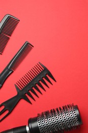 Photo of Different hairdresser's tools on red background, flat lay. Space for text