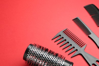 Photo of Different hairdresser's tools on red background, closeup. Space for text