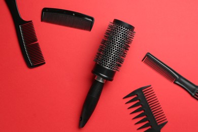 Photo of Different hairdresser's tools on red background, flat lay