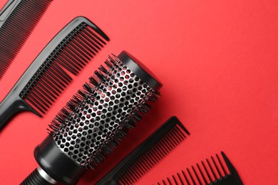 Photo of Different hairdresser's tools on red background, flat lay. Space for text
